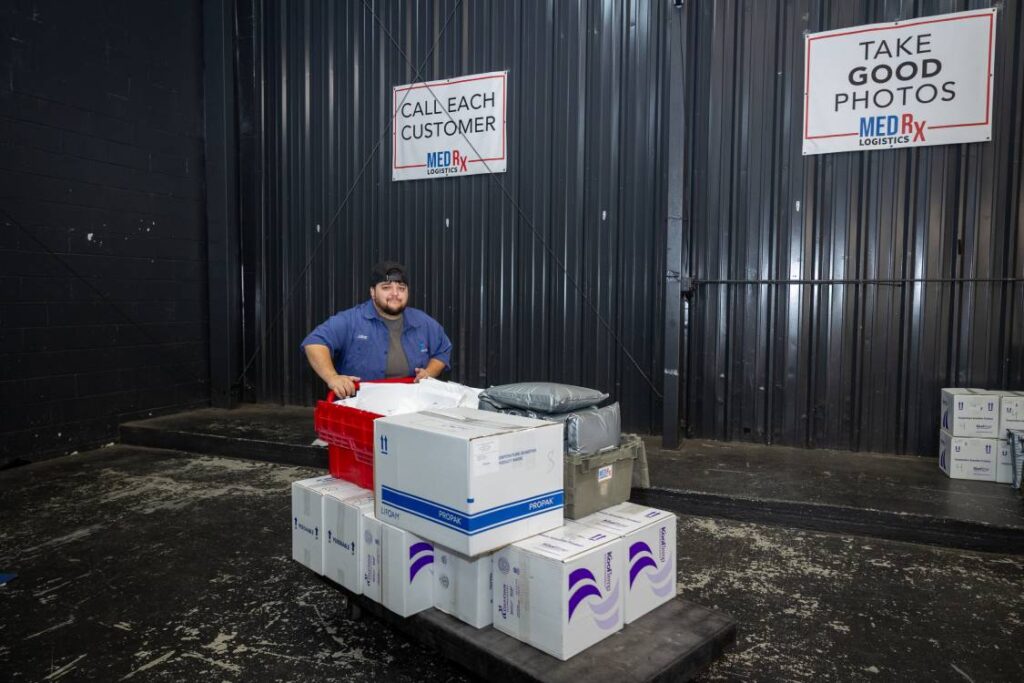 MedRx Logistic Team Member Moving Pharmacy Boxes and Packages to Delivery Vehicle