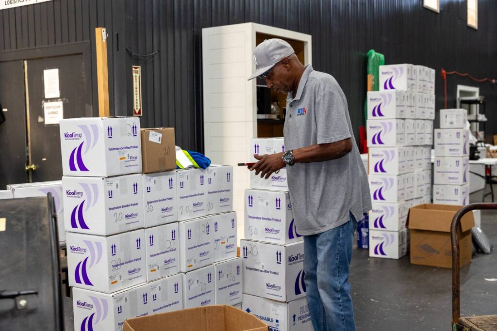 MedRx Logistics Team Driver Reviewing his Delivery Cargo Electronically